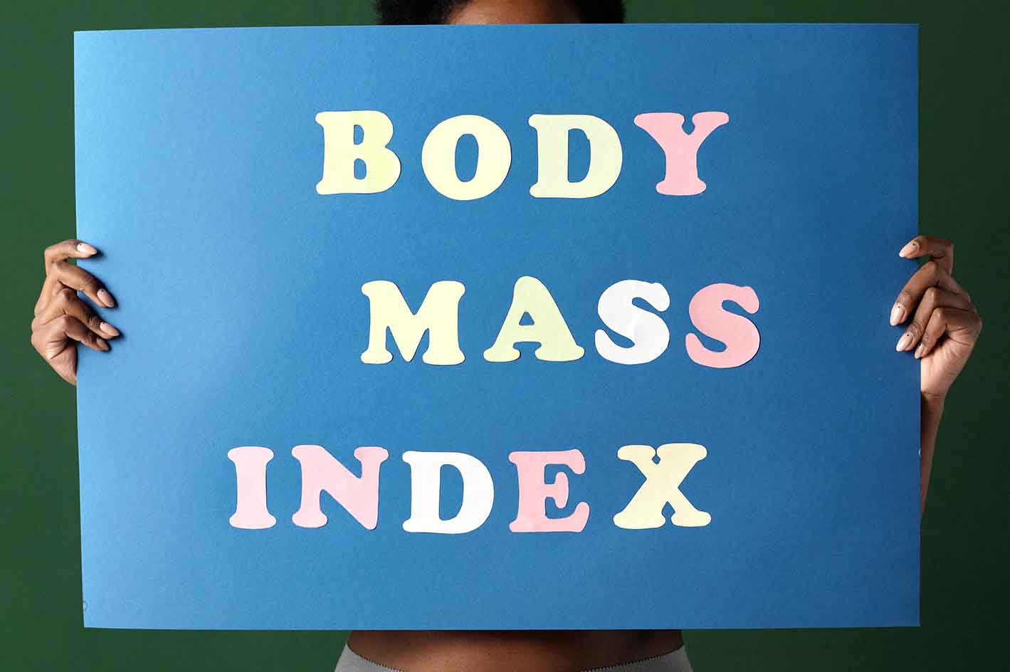 En dame der holder et skilt, hvor der står body mass index.